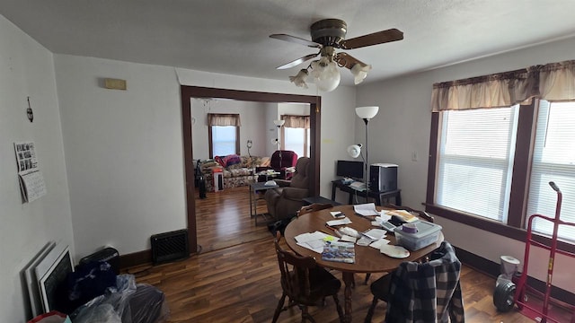 dining area featuring wood finished floors, a healthy amount of sunlight, baseboards, and ceiling fan