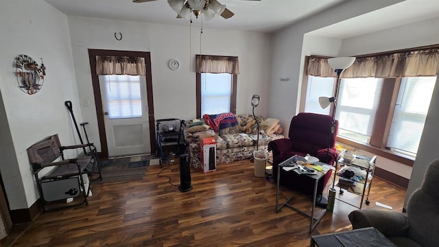 living area with baseboards, ceiling fan, and wood finished floors