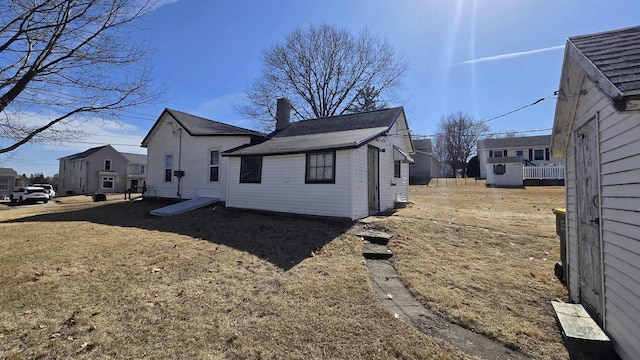 back of property with a residential view and a chimney