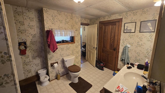 full bath featuring tile patterned floors, toilet, vanity, and wallpapered walls