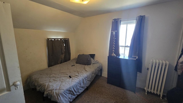 bedroom featuring lofted ceiling, radiator, and carpet floors