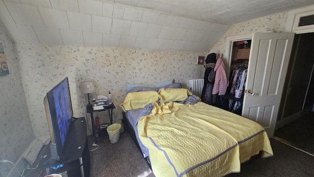 carpeted bedroom with wallpapered walls and vaulted ceiling