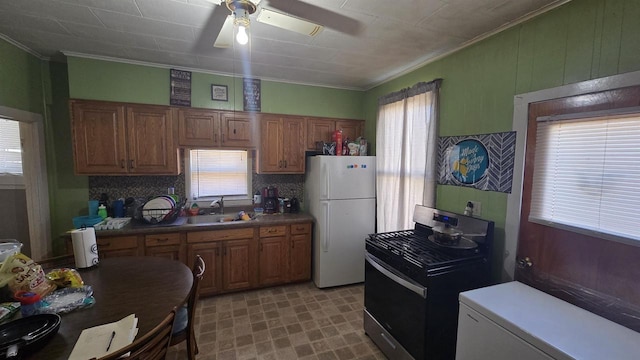 kitchen with crown molding, ceiling fan, black gas range, freestanding refrigerator, and a sink