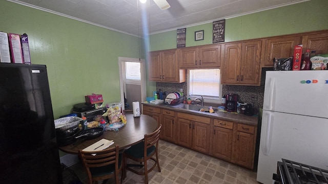 kitchen with a sink, a healthy amount of sunlight, and freestanding refrigerator