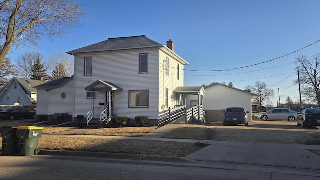 view of front of home featuring a chimney and a shingled roof