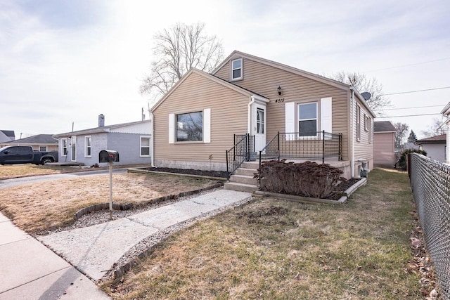 view of front of house featuring a front lawn and fence