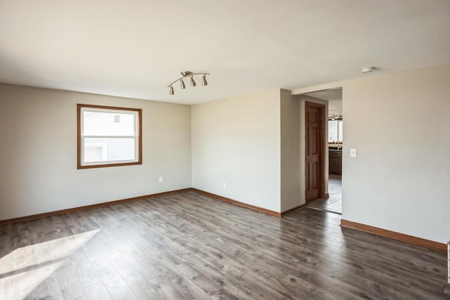 unfurnished room with baseboards and wood finished floors