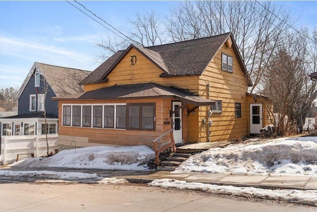 view of front of house featuring roof with shingles and fence