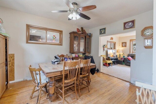 dining space featuring light wood-style floors, baseboards, and ceiling fan