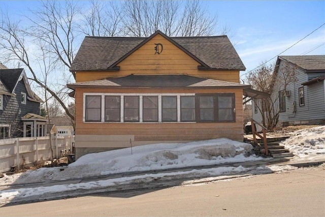 view of front of house featuring fence and roof with shingles