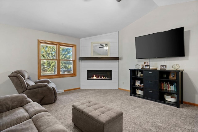 living area with a fireplace, carpet flooring, baseboards, ceiling fan, and vaulted ceiling