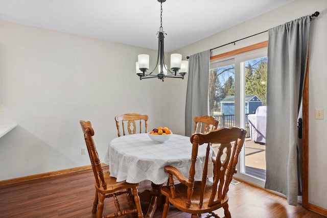 dining room with baseboards, an inviting chandelier, and wood finished floors