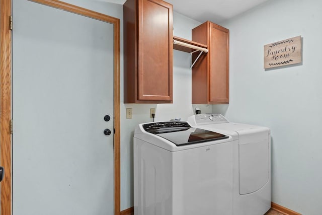 laundry room featuring baseboards, cabinet space, and washing machine and clothes dryer