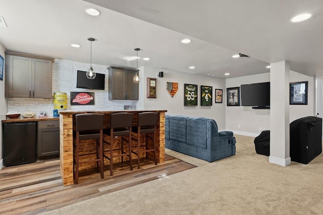 bar featuring recessed lighting, backsplash, fridge, and indoor bar