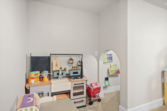 rec room with carpet flooring and baseboards