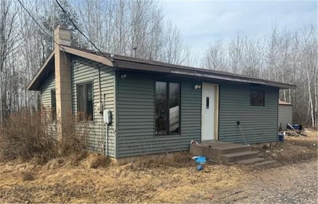 back of property with a chimney