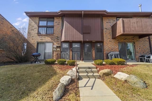 view of front facade featuring a front lawn and a balcony