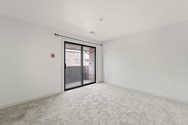 carpeted spare room with visible vents and baseboards