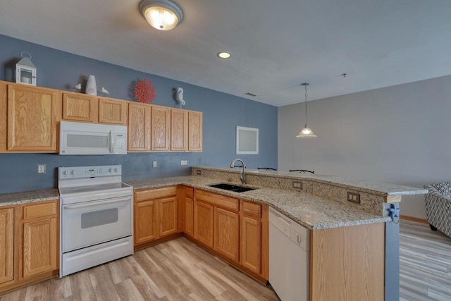 kitchen with light wood finished floors, light stone counters, a peninsula, white appliances, and a sink