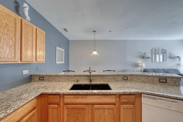 kitchen with a sink, visible vents, light stone counters, and white dishwasher