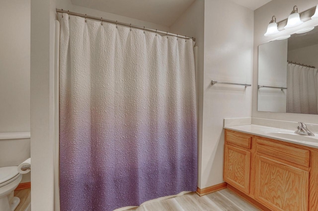 full bath with vanity, toilet, wood finished floors, and baseboards