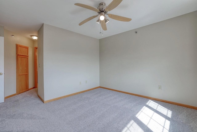 unfurnished room with light colored carpet, baseboards, and ceiling fan