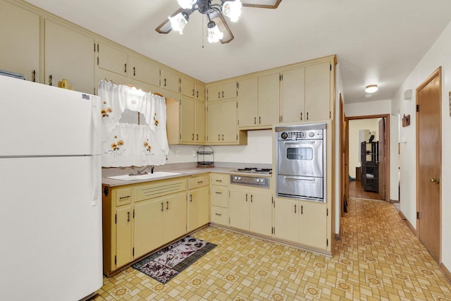 kitchen with a sink, white appliances, cream cabinets, and a warming drawer