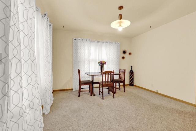 carpeted dining room with baseboards