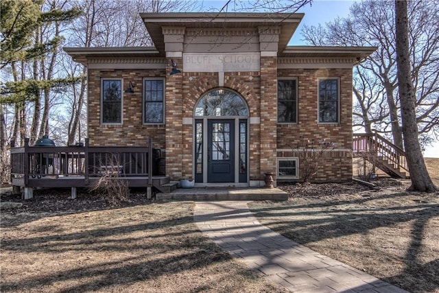 view of front of property with brick siding and a wooden deck