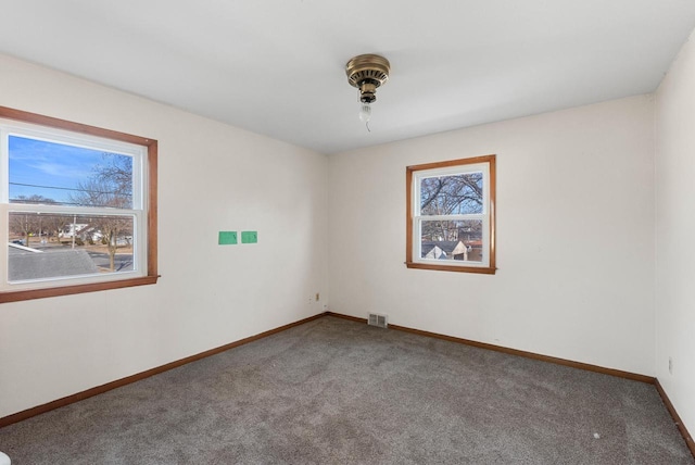 carpeted spare room with visible vents and baseboards