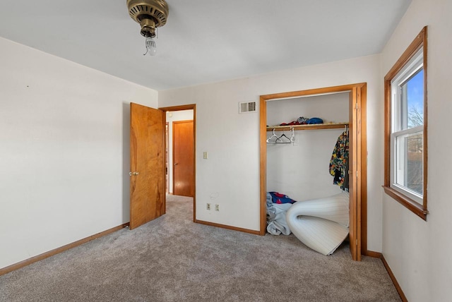 unfurnished bedroom with carpet, visible vents, a closet, and baseboards