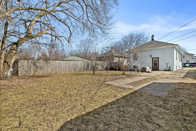 view of yard with central AC and fence