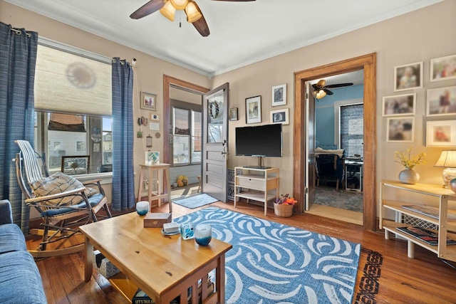 living area with ornamental molding, a ceiling fan, and hardwood / wood-style flooring