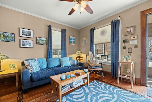 living room featuring baseboards, crown molding, a ceiling fan, and wood finished floors