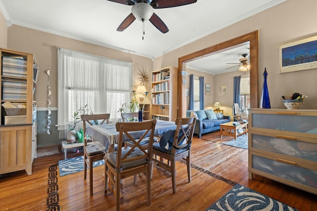 dining area with hardwood / wood-style floors, a ceiling fan, and crown molding