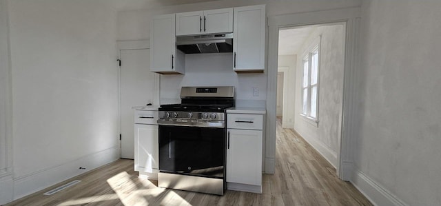 kitchen with gas stove, visible vents, light countertops, under cabinet range hood, and light wood-type flooring