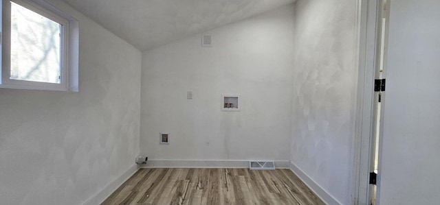 washroom with visible vents, washer hookup, wood finished floors, baseboards, and laundry area