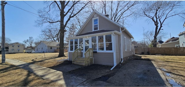 view of front of house featuring a sunroom and fence