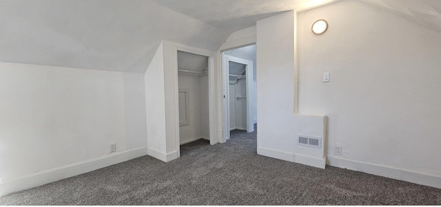 bonus room with visible vents, baseboards, lofted ceiling, and dark colored carpet