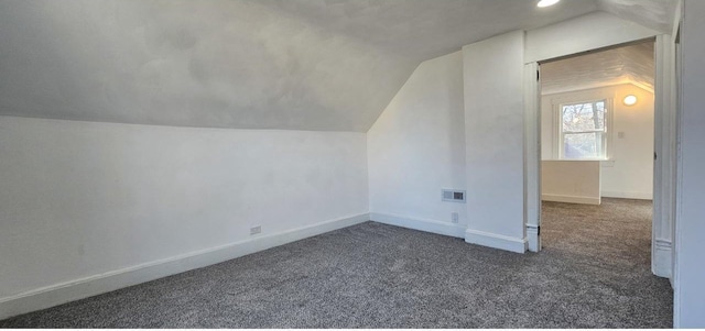 additional living space featuring visible vents, baseboards, carpet, and lofted ceiling