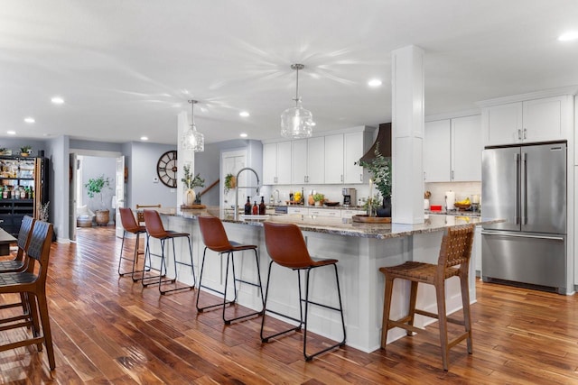 kitchen featuring premium range hood, dark wood-type flooring, white cabinets, and high end refrigerator