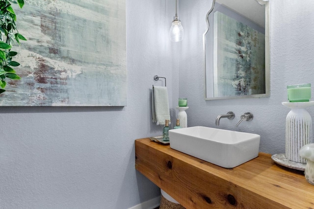 bathroom with vanity and a textured wall