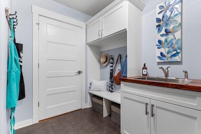 mudroom with baseboards and a sink