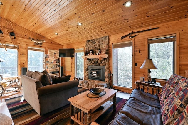 living area with wooden walls, wooden ceiling, a fireplace, and vaulted ceiling