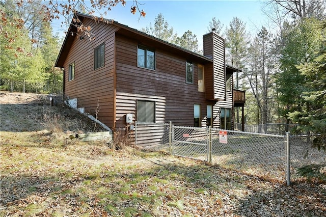 rear view of property with fence private yard, a chimney, and a gate