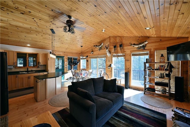 living area featuring vaulted ceiling, a healthy amount of sunlight, light wood-style floors, and wooden ceiling