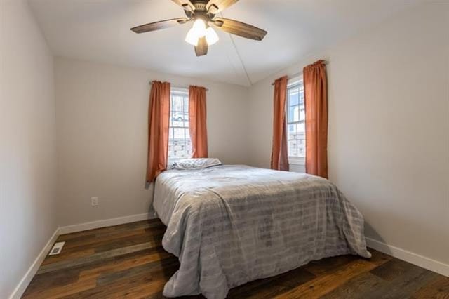 bedroom featuring baseboards, wood finished floors, and a ceiling fan