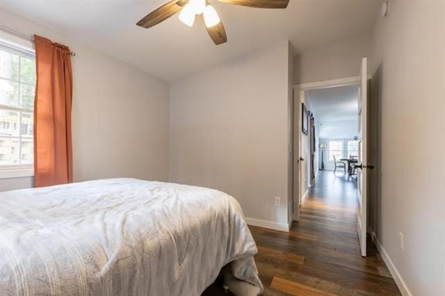 bedroom with a ceiling fan, baseboards, and dark wood-style flooring