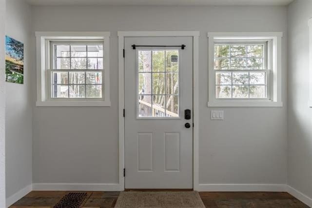 doorway featuring baseboards and dark wood-style flooring