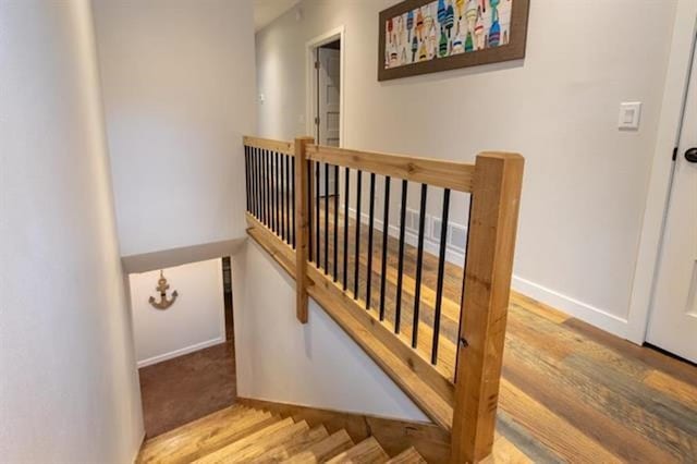 stairway featuring baseboards and wood finished floors